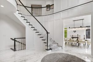 A large white room with stairs and a table