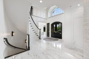 A large white foyer with a spiral staircase.