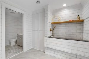 A bathroom with white tile and tiled walls.